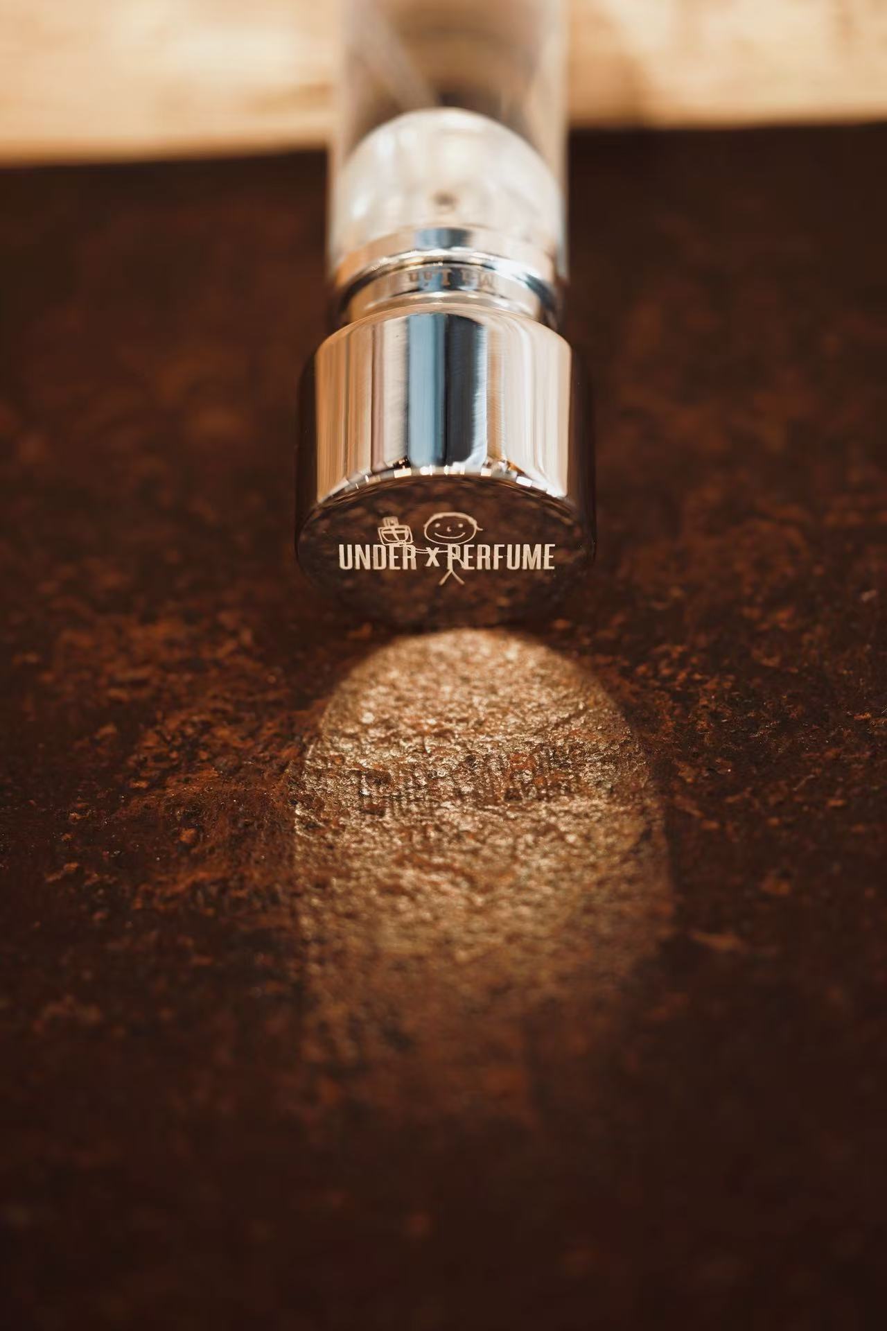 Perfume bottle detail on a warm dark surface